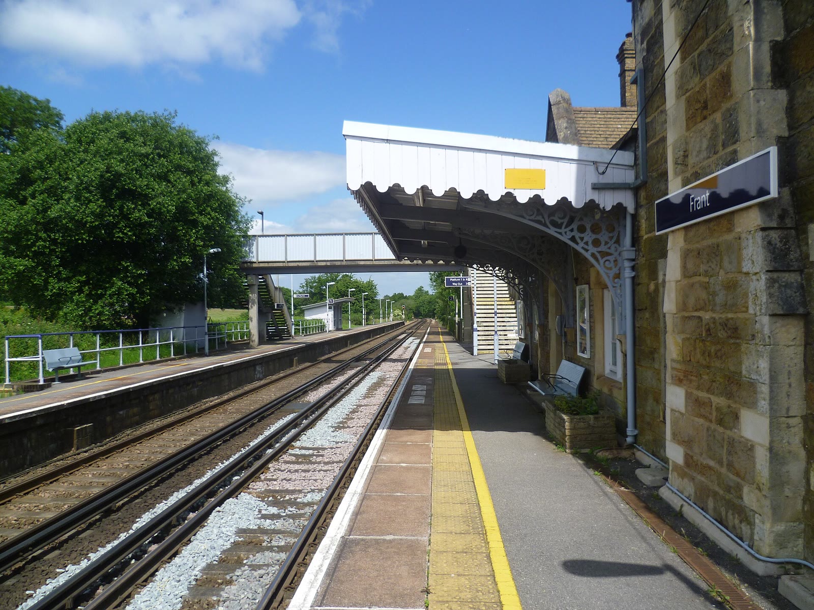 The stone Gothic-style building of Frant station at Bells Yew Green, beside the platform.